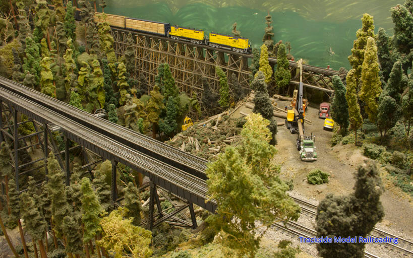 Loggers work in the woods near Ostrander. Here, a Weyerhaeuser Woods Railroad train crosses the trestle on the branch line.
